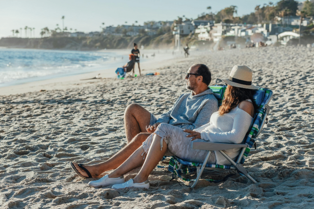 A happy retired couple on a beach, representing the ultimate goal for why you should learn how to open a Fidelity IRA.